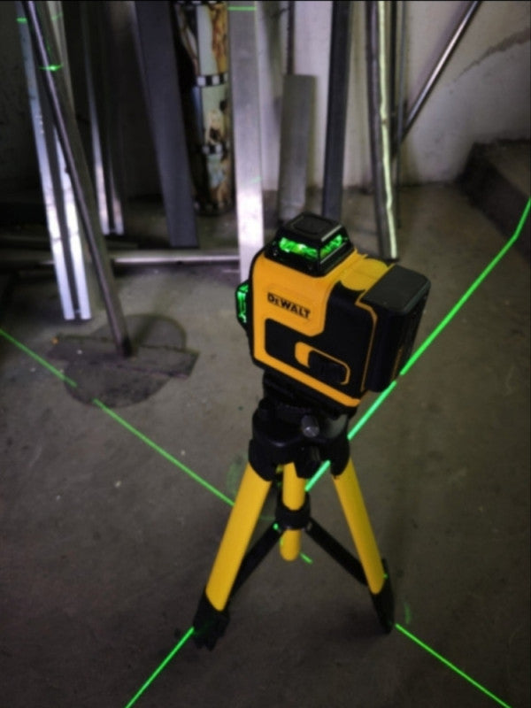 Laser na stativu iscrtava zelene linije po podu gradilišta