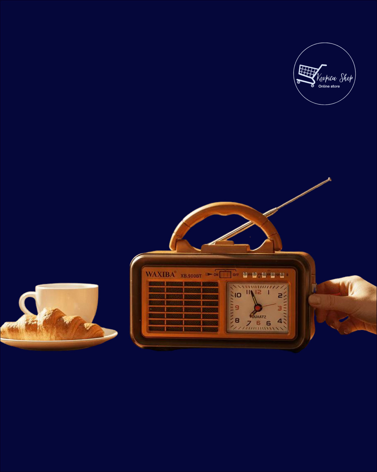 Retro prijenosni radio sa satom pored šoljice kafe i kroasana